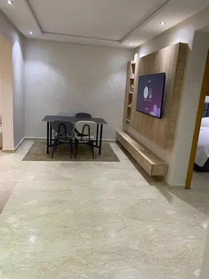 a room with a table and two chairs and a tv at Apartment Ocean view in Oulad Akkou