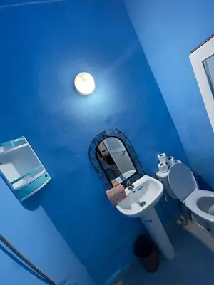a blue bathroom with a sink and a mirror at Dar Bladi -A Quiet Place to Reset in Fes in Fès