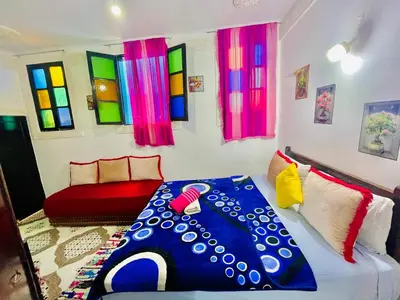a living room with a bed and colorful windows at Dar Bladi -A Quiet Place to Reset in Fes in Fès