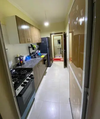 a small kitchen with a stove and a refrigerator at شقة اسراء قريبة من مطار مراكش المنارة الدولي in Oulad Akkou