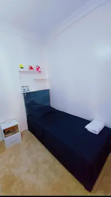 a bedroom with a blue bed in a white room at شقة اسراء قريبة من مطار مراكش المنارة الدولي in Oulad Akkou
