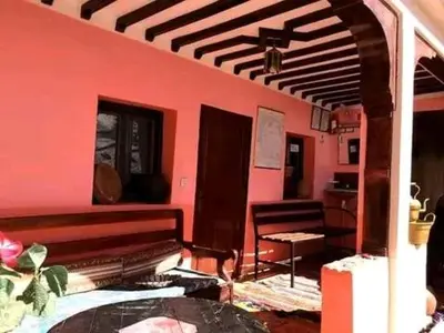 a room with a bench and a pink wall at Gite Likemte Tachdirt in Tacheddirt