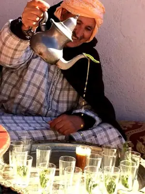 a man with an orange hijab is pouring aousandousandousandousandousandousandousand at Gite Likemte Tachdirt in Tacheddirt