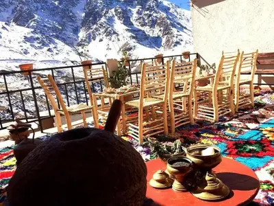 a person sitting at a table with a view of a mountain at Gite Likemte Tachdirt in Tacheddirt