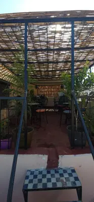 a checkered checkerboard table in a room with tables at Riad zineb in Fès