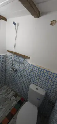a bathroom with a toilet and a lamp on the wall at Riad zineb in Fès