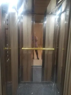 a person standing behind a glass wall in a elevator at Appartement á Loisis á Bensimane in Oulad Akkou