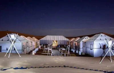 a row of tents in the desert at night at Nada luxury desert camp in Merzouga