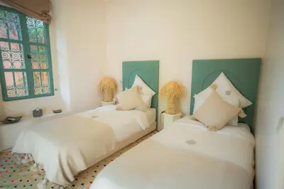 a bedroom with two beds and a window at Villa luxe ADAMA avec gouvernante- Marrakech in Marrakech