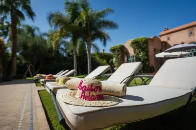 a row of lounge chairs with hats on them at Villa luxe ADAMA avec gouvernante- Marrakech in Marrakech