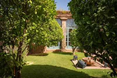 a house with a yard with trees in front of it at Villa luxe ADAMA avec gouvernante- Marrakech in Marrakech