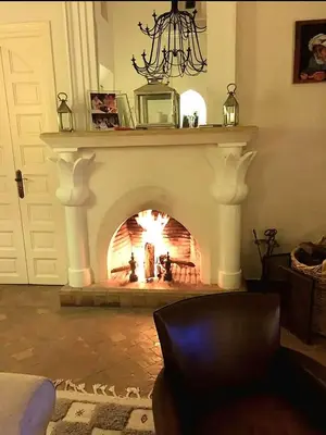 a fireplace in a living room with a fire place at Villa luxe ADAMA avec gouvernante- Marrakech in Marrakech