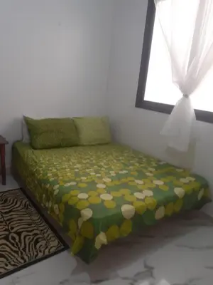 a bed sitting in a room with a window at Petit appartement in Meknès
