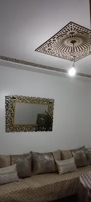 a mirror and a couch in a living room at Petit appartement in Meknès
