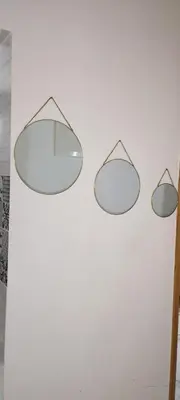 two mirrors hanging on a white wall at Petit appartement in Meknès