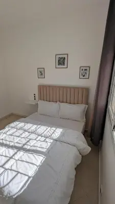 a bedroom with a large bed with white sheets at Apartment 2-Bedroom 20 minutes from downtown in Oulad Akkou