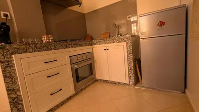 a kitchen with white cabinets and a refrigerator at Apartment 2-Bedroom 20 minutes from downtown in Oulad Akkou