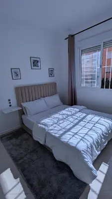 a large bed in a bedroom with a window at Apartment 2-Bedroom 20 minutes from downtown in Oulad Akkou