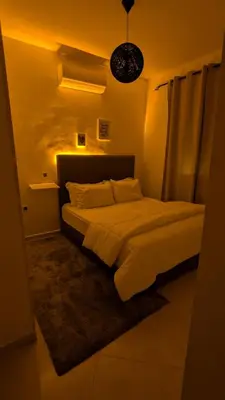a bedroom with a large bed with a light at Apartment 2-Bedroom 20 minutes from downtown in Oulad Akkou