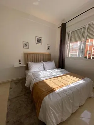 a bedroom with a large bed with white sheets and a window at Apartment 2-Bedroom 20 minutes from downtown in Oulad Akkou