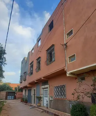 an orange building with a white door and windows at Appartement for Rent Near Marrakech in Aït Ourir