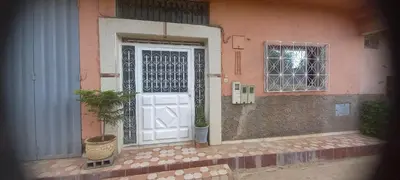 a white door with a potted plant in front of a building at Appartement for Rent Near Marrakech in Aït Ourir