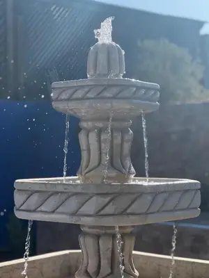 a stone fountain with water coming out of it at Duplex de rêve en face du jardin majorelle in Oulad Akkou