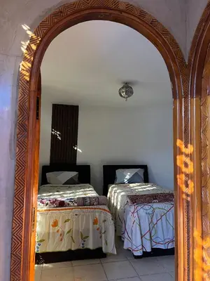 an archway with two beds in a room at Duplex de rêve en face du jardin majorelle in Oulad Akkou