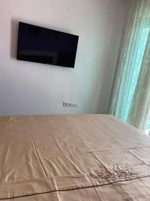 a bedroom with a bed with a flat screen tv on the wall at منزل لزعر in Moulay Yacoub
