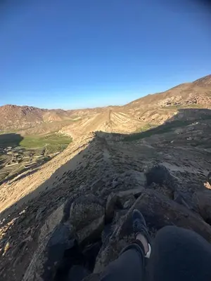 a person sitting on the edge of a rocky mountain at Anmid Tigmi in Tagdourt
