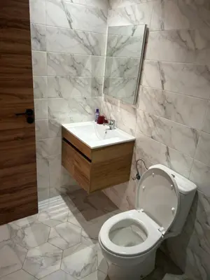 a bathroom with a toilet and a sink and a mirror at Les jardins de temara in Oulad Akkou