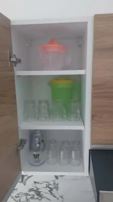 a cabinet filled with glasses and other items at Les jardins de temara in Oulad Akkou
