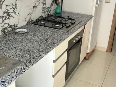 a kitchen with a stove and a counter top at Les jardins de temara in Oulad Akkou