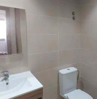 a bathroom with a white toilet and a sink at Les jardins de temara in Oulad Akkou