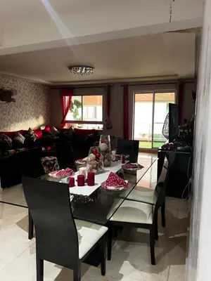 a living room with a table and chairs and a couch at Dyar lbahr in Oulad Akkou