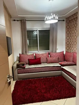 a living room with a couch with red pillows at Dyar lbahr in Oulad Akkou
