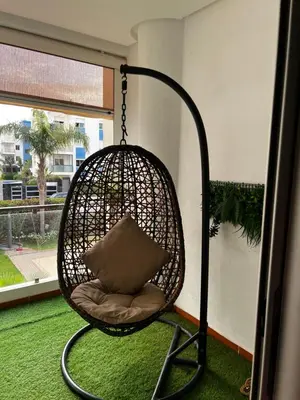 a hanging chair with a pillow in a room at Dyar lbahr in Oulad Akkou