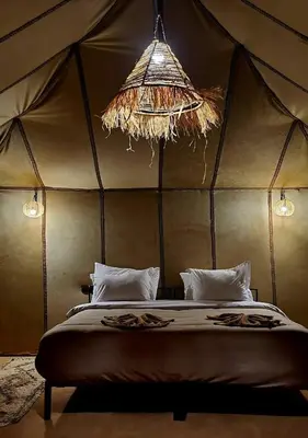 a bedroom with a bed in a tent at Yamanda luxury camp in Merzouga
