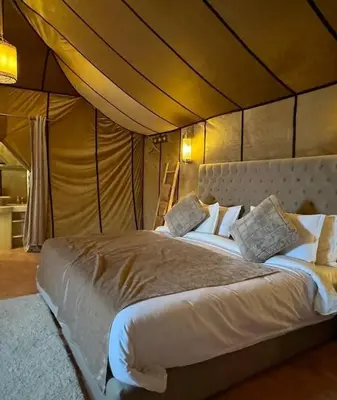 a bedroom with a large bed in a tent at Yamanda luxury camp in Merzouga