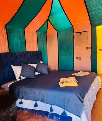 a bedroom with a bed in a room with colorful walls at Yamanda luxury camp in Merzouga