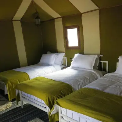 a room with three beds in a room at Yamanda luxury camp in Merzouga