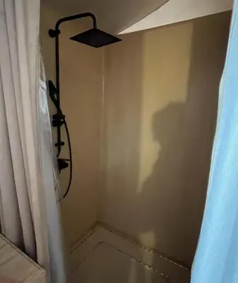 a shower in a bathroom with a shower curtain at Yamanda luxury camp in Merzouga