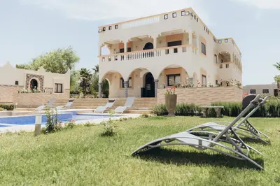 a house with a pool and a sculpture in the yard at Villa La Rêverie in Ain Cheggag