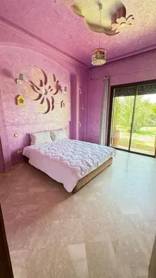 a bedroom with purple walls and a large bed at Beautiful Moroccan-style villa in Douar Soukkane