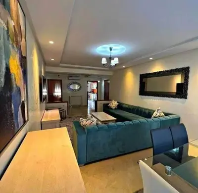a living room with a green couch and a table at Appart bien meublé pour location in Oulad Akkou