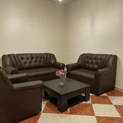 two leather couches and a coffee table in a living room at Résidence Kawtar Meknès in Meknès