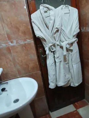 a bathroom with a sink and a toilet and towels at Résidence Kawtar Meknès in Meknès