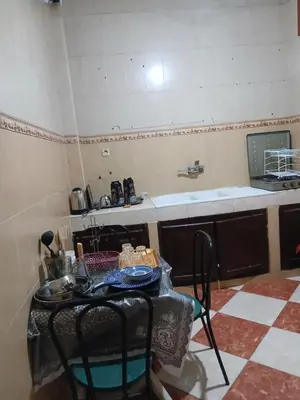 a kitchen with a table with chairs and a counter at Résidence Kawtar Meknès in Meknès