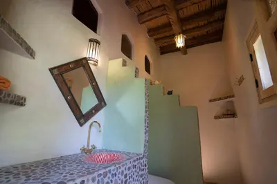 a bathroom with a sink and a mirror and stairs at Casa Juan in Tagounite