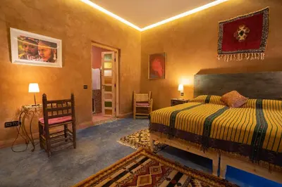 a bedroom with a bed and a table and a chair at Casa Juan in Tagounite